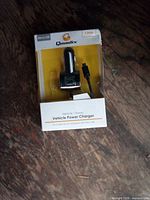Front view of packaged Qmadix vehicle power charger showing product and branding