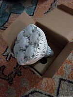 Top view of Sansi LED bulb in open box showing seven LED modules