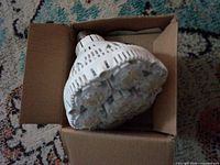 Sansi LED bulb resting in open cardboard box showing LED clusters and screw base