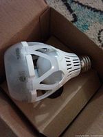 LED bulb inside box, showing cage heat-sink and screw base