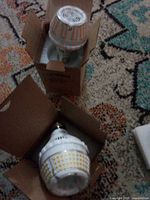 Two Sansi LED bulbs in open boxes showing overall design