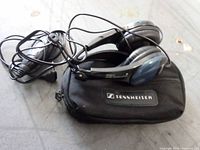 Headphones coiled atop Sennheiser-branded zippered case