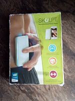 Front of retail box showing Skulpt device and app interface