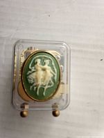 Top view of transparent music box showing green cameo with white dancers and inner mechanism