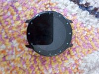 Front view of round black smartwatch face on patterned surface