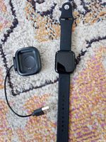 Smartwatch front view with charger and USB cable