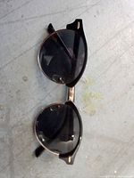 Full view of the black and gold round sunglasses