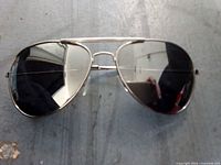 Front view of metal aviator sunglasses on flat surface