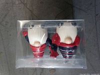 Two small gnome figurines sealed in clear plastic packaging