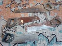 All four saws laid out on rug showing overall condition