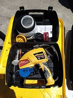 Open carrying case showing Wagner paint sprayer, paint cup, attachments, and manual