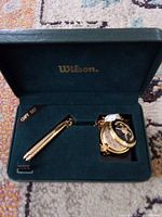 Open Wilson presentation case showing gold-tone pocket knife and pocket watch with chain