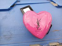 Front view of pink heart YSL Beauté pouch with attached mirror