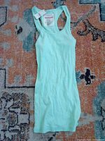Front view of mint green Zenana Outfitters ribbed racerback tank top with tag showing size M