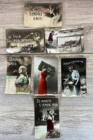 Fronts of seven Italian postcards laid out on wood surface