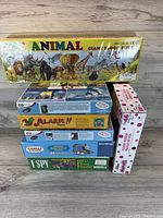 Front view of five boxed puzzles stacked, showing titles and themes