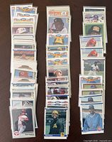 Three stacks of sleeved baseball cards on table