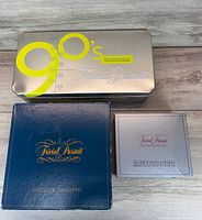 Trivial Pursuit 90's Time Capsule tin, Mastergame Genus Edition box, Silver Screen Edition box top view