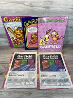 Lot overview showing three folders and two sealed book cover packs