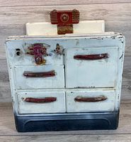 Front view of toy stove showing doors, handles, wear