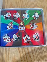 Open box showing full pin set on rainbow card