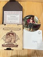 Plate, certificate, box and pamphlet displayed on table