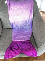 Full mermaid tail blanket draped on chair showing overall design and fin