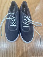 Top view of both sneakers showing canvas uppers, laces, size tags