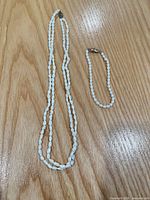 Necklace and bracelet laid flat showing overall size and pearl shape