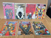 Eight bagged comics laid out showing full covers