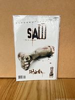 Front view of bagged SAW: Rebirth #1 comic