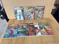 Top-down view showing all seven bagged trade paperbacks on table