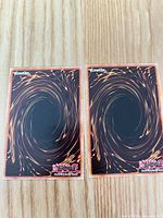 Two Yu-Gi-Oh card backs in sleeves