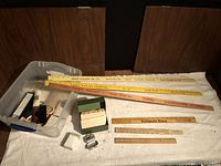 Overview of lot showing yardsticks, folding rulers, index card box, pedometer, accessories