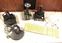 Overall view of two joysticks, black trackball-style mouse, keyboard and cables