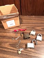 box and six padlocks with keys on table