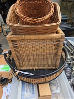 Stacked view showing all five woven pieces including black tray at bottom, square wood basket, round wicker bowl