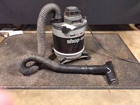 Full view of Shop-Vac with hose and floor nozzle on mat