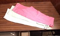 Three pairs of leggings stacked showing colors and ankle snap detail