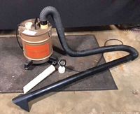 Complete lot showing canister vacuum, hose, wand, and attachments