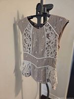Front view of lace peplum blouse on hanger
