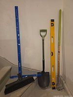 Overall lot showing shovel, broom head, cultivator, level, handle