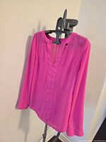 Front view of hot pink chiffon Guess blouse on hanger