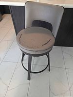 Single counter stool front view showing seat wear and metal frame