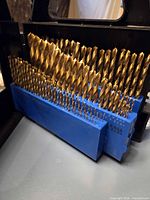 Rows of gold titanium-coated bits in blue holder inside black case
