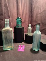Group view of Hemingray insulator and three aqua bottles