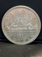 Reverse of 1965 Canadian Voyageur silver dollar showing canoe design and date