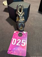 Front view of carved pendant showing looped head and torso