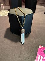 Full view of quartz point pendant necklace on display box