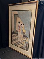 Full view of framed artwork leaning against backdrop